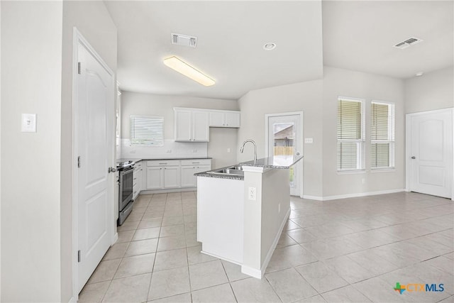 1041 Lakeway Crossing Dr, Temple, TX 76502 - kitchen with a sink, light tile patterned floors, stainless steel electric stove, and white cabinetry