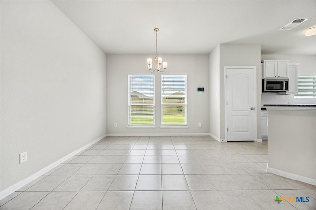 1041 Lakeway Crossing Dr, Temple, TX 76502 - unfurnished dining area featuring a chandelier, light tile patterned floors, and baseboards