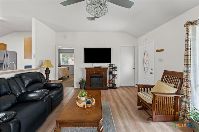 605 Aikman Dr, Troy, TX 76579 - living room featuring ceiling fan, vaulted ceiling, light wood-style floors, and a glass covered fireplace