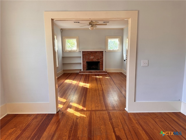 unfurnished living room featuring hardwood / wood-style floors, a fireplace, crown molding, and ceiling fan