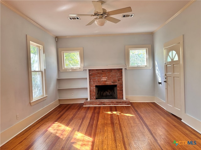 unfurnished living room featuring crown molding, hardwood / wood-style floors, ceiling fan, and a brick fireplace