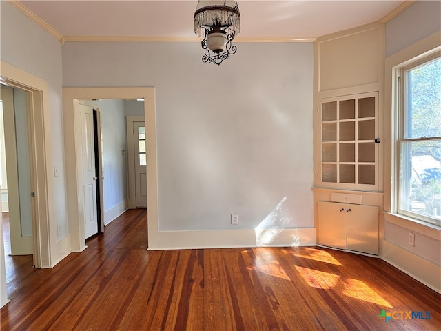 unfurnished dining area with ornamental molding, a notable chandelier, and dark hardwood / wood-style floors