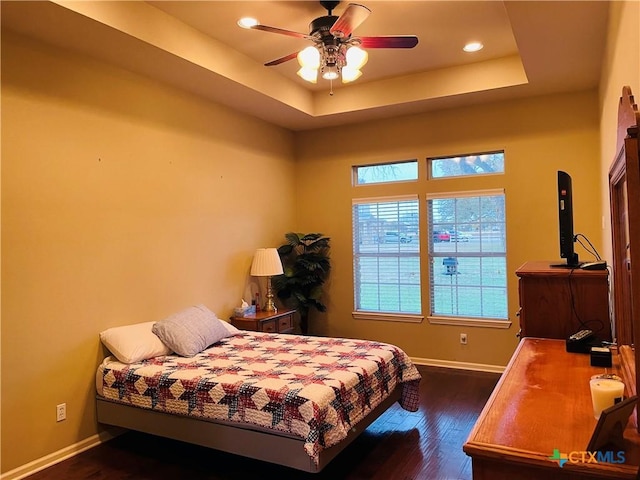 bedroom featuring dark hardwood / wood-style floors and a raised ceiling