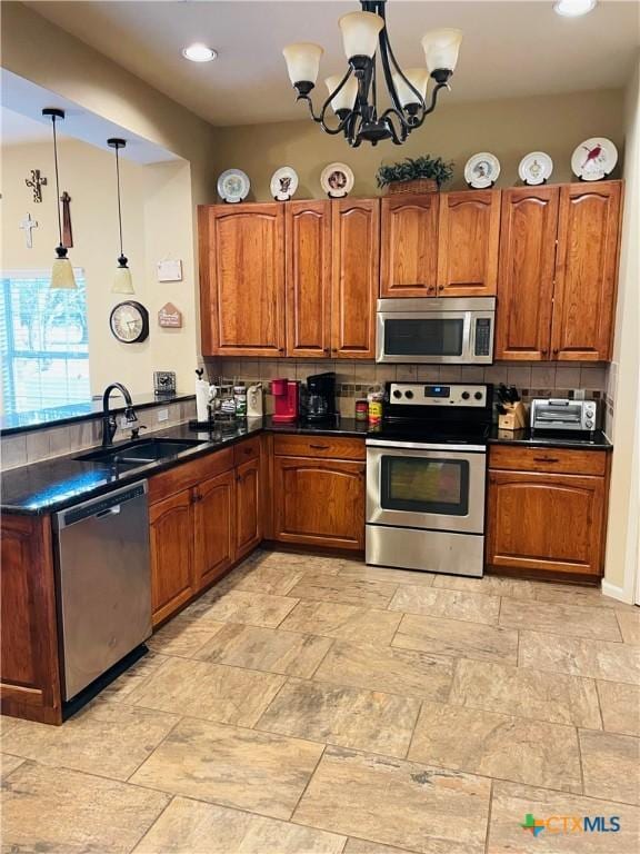 kitchen featuring appliances with stainless steel finishes, decorative light fixtures, sink, and decorative backsplash