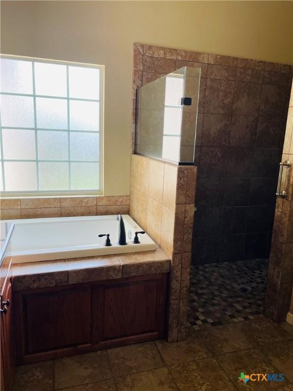 bathroom featuring a tile shower and a garden tub