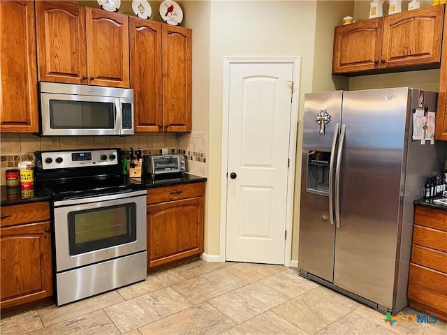 kitchen featuring stainless steel appliances and decorative backsplash