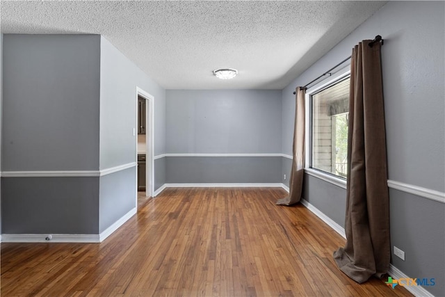 1404 N Beal St, Belton, TX 76513 - unfurnished room featuring wood-type flooring, a textured ceiling, and baseboards