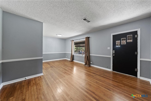 1404 N Beal St, Belton, TX 76513 - empty room with wood-type flooring, baseboards, and a textured ceiling