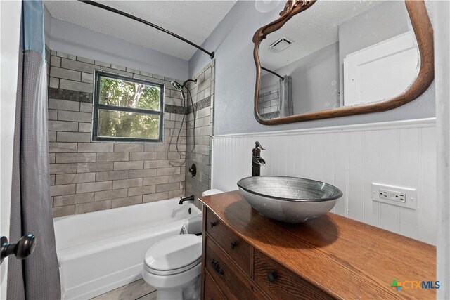 1404 N Beal St, Belton, TX 76513 - bathroom with shower / bath combination with curtain, vanity, a wainscoted wall, and toilet