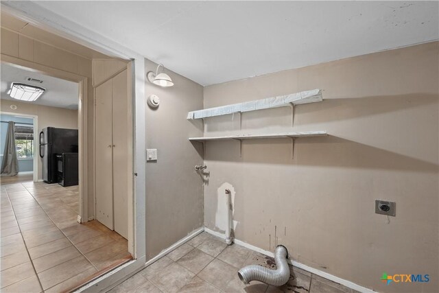 1404 N Beal St, Belton, TX 76513 - washroom with hookup for an electric dryer, light tile patterned flooring, and baseboards