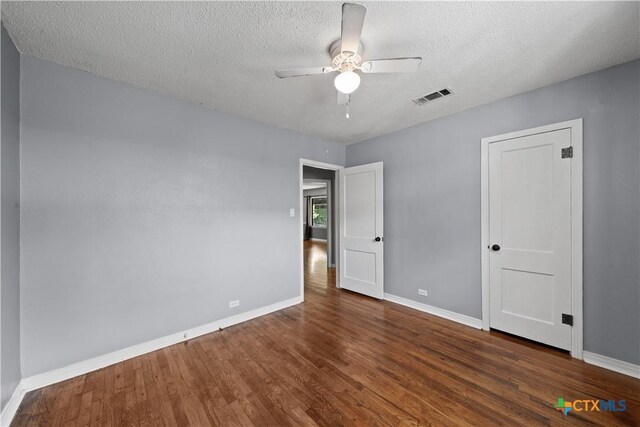 1404 N Beal St, Belton, TX 76513 - unfurnished bedroom with wood finished floors, baseboards, a textured ceiling, and a ceiling fan