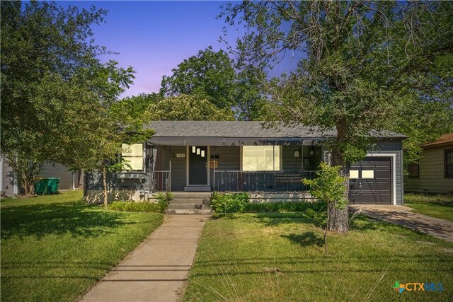 1404 N Beal St, Belton, TX 76513 - ranch-style house featuring an attached garage, a porch, driveway, and a lawn