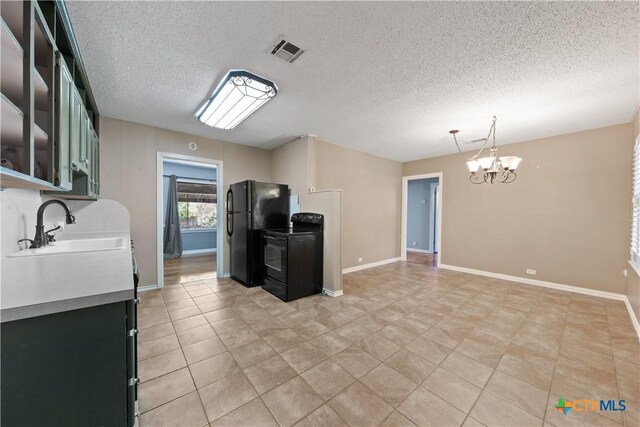 1404 N Beal St, Belton, TX 76513 - kitchen featuring black appliances, a chandelier, a sink, light countertops, and baseboards