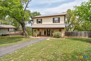 25420 Cove Dr, Spicewood, TX 78669 - view of front facade with covered porch, fence, a front lawn, and driveway
