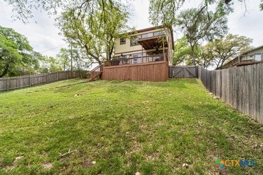 25420 Cove Dr, Spicewood, TX 78669 - view of yard featuring stairway, a wooden deck, and a fenced backyard