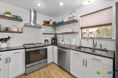 25420 Cove Dr, Spicewood, TX 78669 - kitchen featuring open shelves, wall chimney exhaust hood, appliances with stainless steel finishes, and a sink