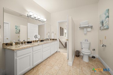 25420 Cove Dr, Spicewood, TX 78669 - full bath with baseboards, toilet, double vanity, and a sink