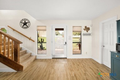 25420 Cove Dr, Spicewood, TX 78669 - doorway to outside with baseboards, stairway, and light wood-style floors