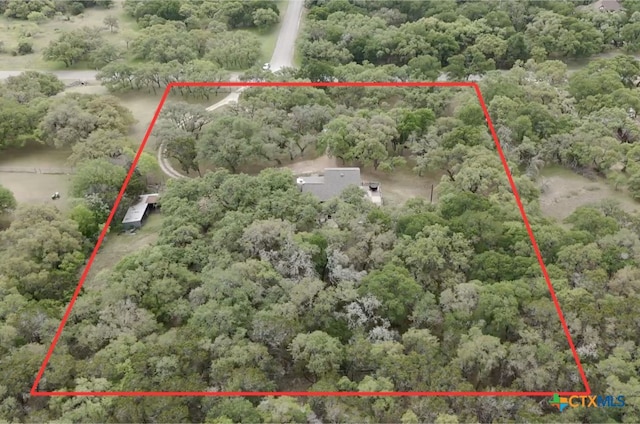 drone / aerial view featuring a wooded view