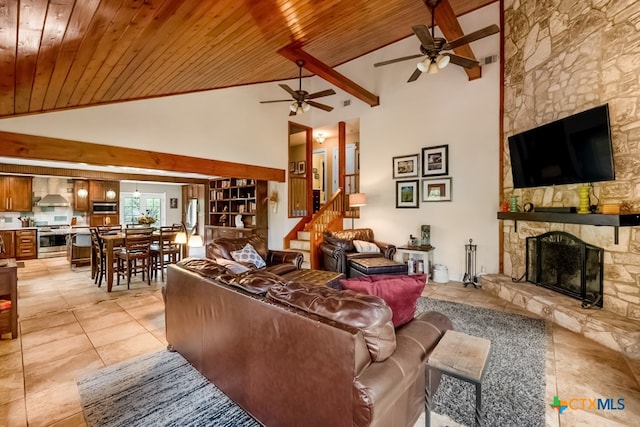 living area featuring a fireplace, light tile patterned floors, ceiling fan, and wood ceiling