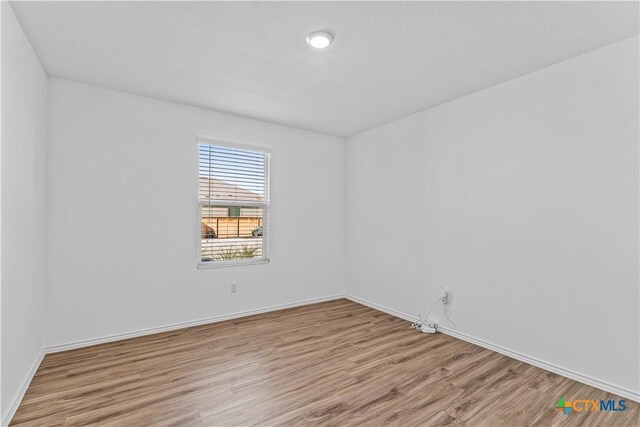 130 Carmello, Kyle, TX 78640 - spare room featuring baseboards and light wood-style flooring