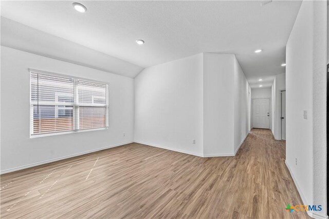130 Carmello, Kyle, TX 78640 - spare room featuring baseboards, recessed lighting, vaulted ceiling, and light wood-style floors