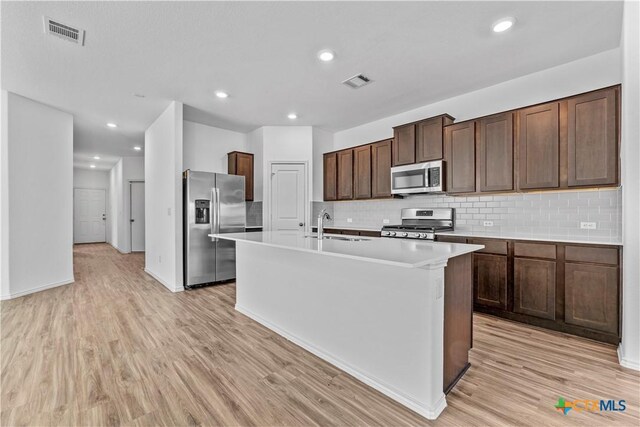 130 Carmello, Kyle, TX 78640 - kitchen featuring light wood-style flooring, visible vents, stainless steel appliances, and a kitchen island with sink