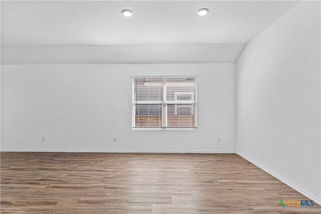 130 Carmello, Kyle, TX 78640 - unfurnished room featuring recessed lighting, baseboards, lofted ceiling, and wood finished floors