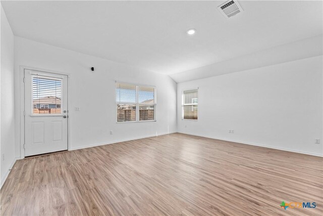 130 Carmello, Kyle, TX 78640 - unfurnished room with baseboards, lofted ceiling, visible vents, and light wood-style floors
