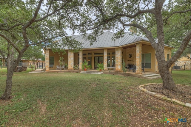 view of front of property featuring a front yard and a patio