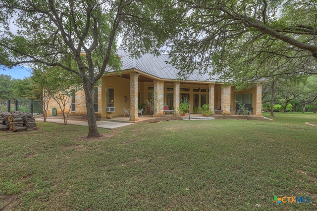 back of property featuring a patio area and a lawn