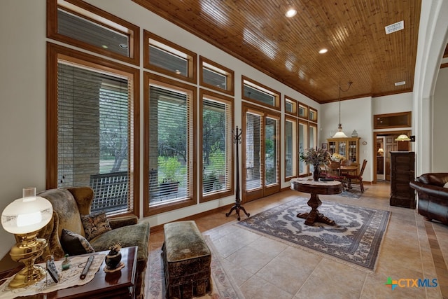 living area with ornamental molding, light tile patterned flooring, and wooden ceiling