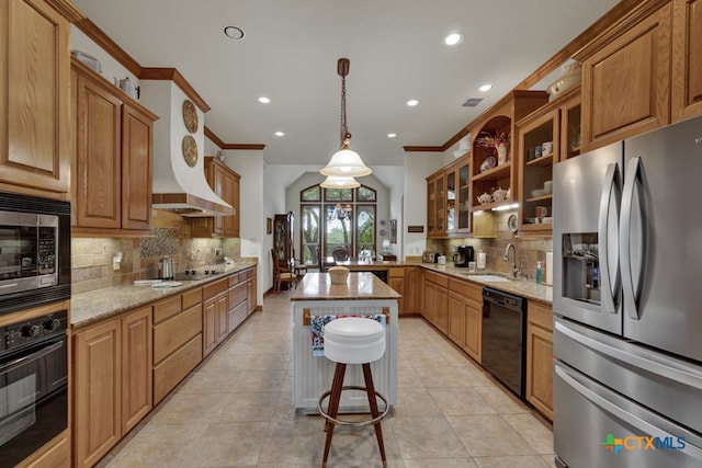 kitchen with sink, crown molding, a kitchen island, light stone countertops, and black appliances