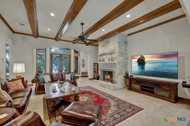 197 Falling Hls, New Braunfels, TX 78132 - tiled living room featuring a ceiling fan, beamed ceiling, arched walkways, baseboards, and a fireplace