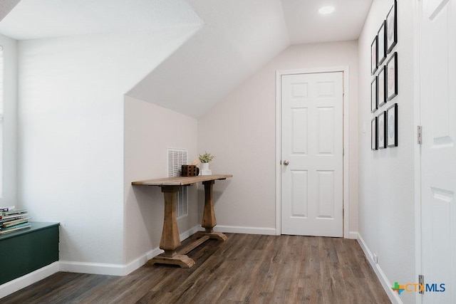 interior space featuring lofted ceiling, visible vents, baseboards, and wood finished floors