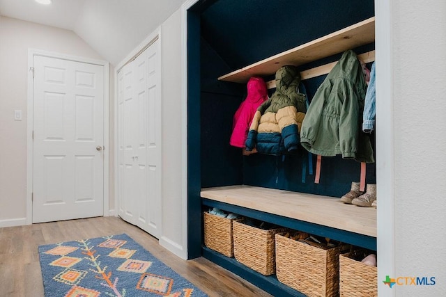 mudroom with vaulted ceiling, baseboards, and wood finished floors