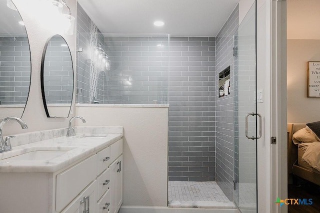 full bath with recessed lighting, a sink, a shower stall, and double vanity