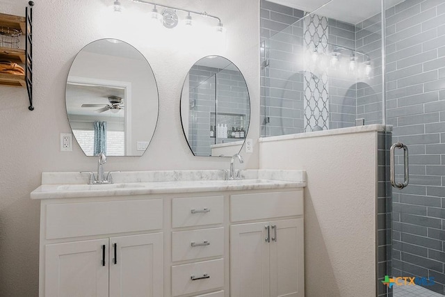 bathroom featuring double vanity, a shower stall, ceiling fan, and a sink