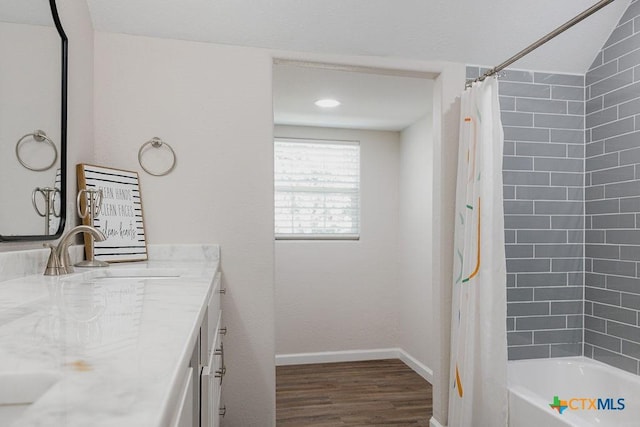 full bathroom with baseboards, wood finished floors, shower / tub combo with curtain, and vanity