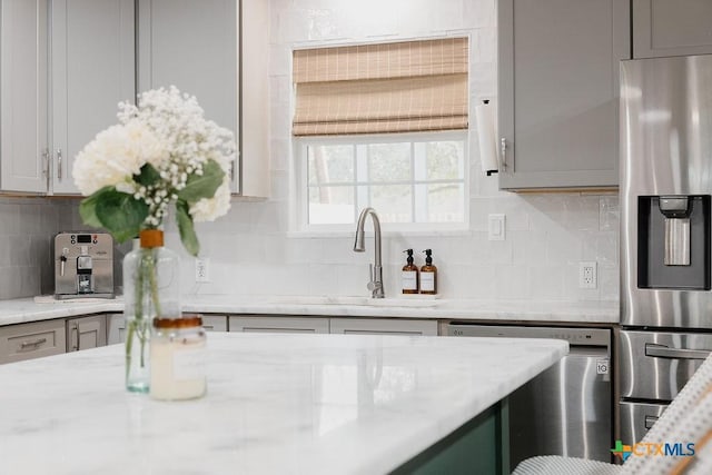 kitchen with stainless steel appliances, gray cabinets, and decorative backsplash