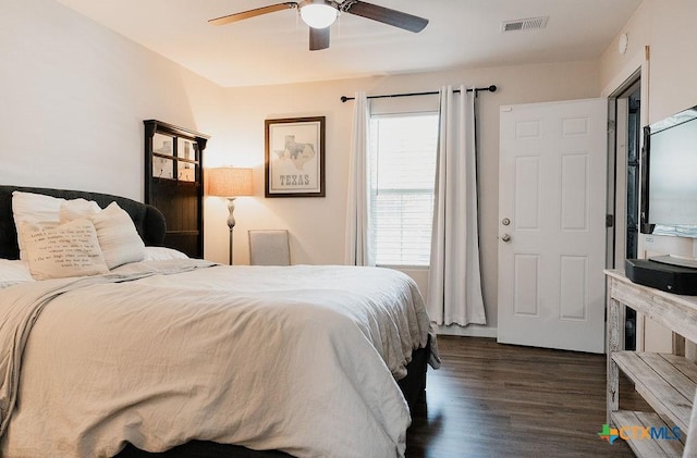 bedroom with ceiling fan, visible vents, and dark wood-style flooring