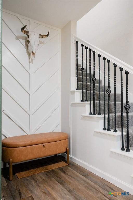 stairs with wood finished floors and baseboards