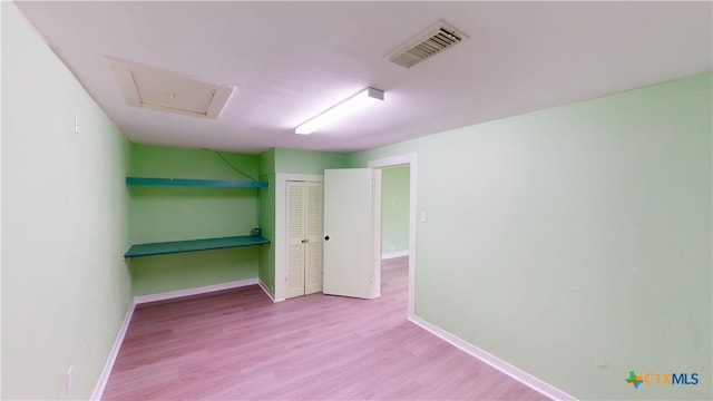 unfurnished bedroom with light hardwood / wood-style floors and a closet