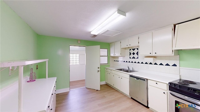 kitchen with white cabinetry, sink, appliances with stainless steel finishes, tasteful backsplash, and light wood-type flooring