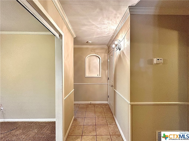 hallway featuring light tile patterned floors and crown molding