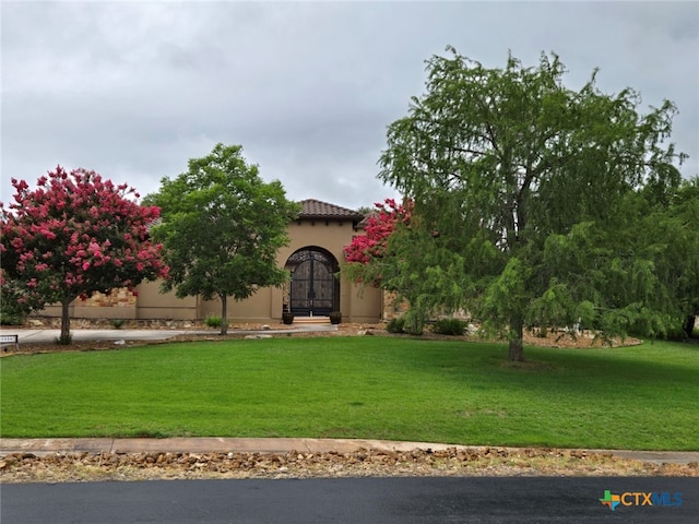 mediterranean / spanish-style home featuring a front yard