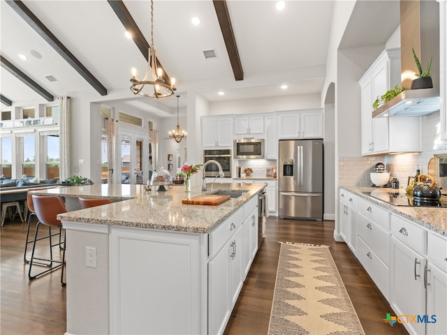 4508 River Rock Rd, Marion, TX 78124 - kitchen with appliances with stainless steel finishes, a sink, wall chimney range hood, a chandelier, and a large island with sink