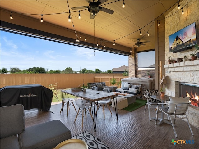 4508 River Rock Rd, Marion, TX 78124 - fenced backyard featuring an outdoor living space with a fireplace, a ceiling fan, and outdoor dining space