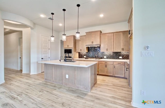 kitchen with gas stovetop, light brown cabinetry, a center island with sink, and sink