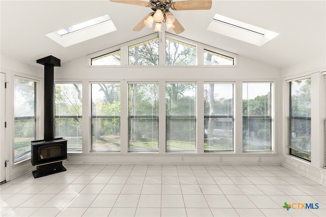 sunroom / solarium with a wood stove, lofted ceiling with skylight, and ceiling fan